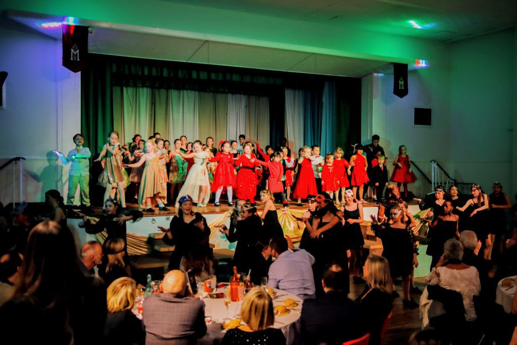 Children performing on stage at event.