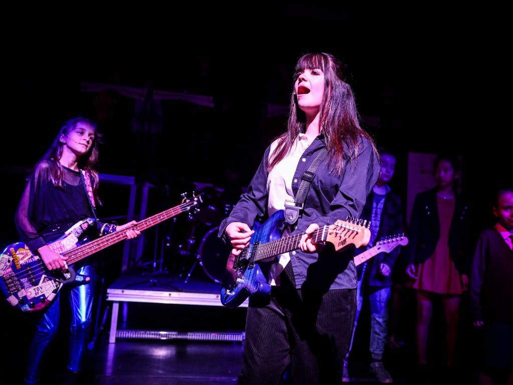 Band performing on stage at night.