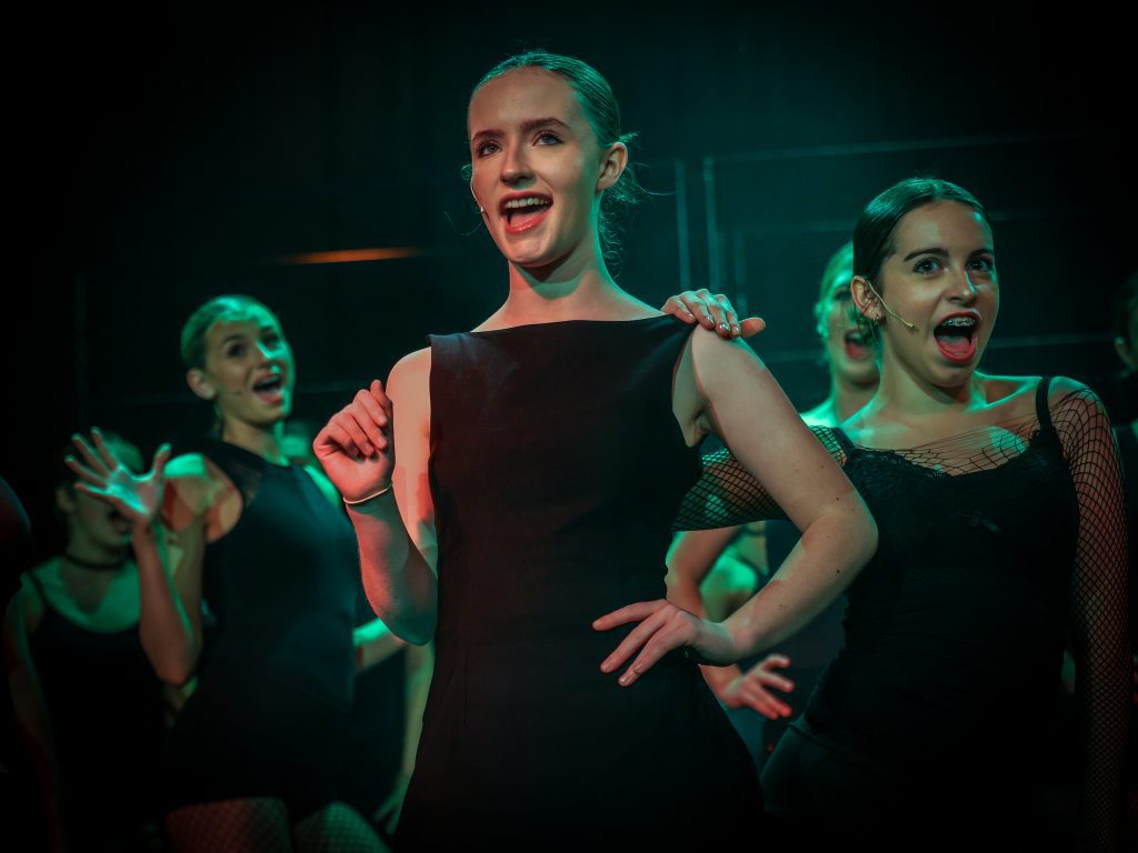 Dancers performing in dramatic lighting.
