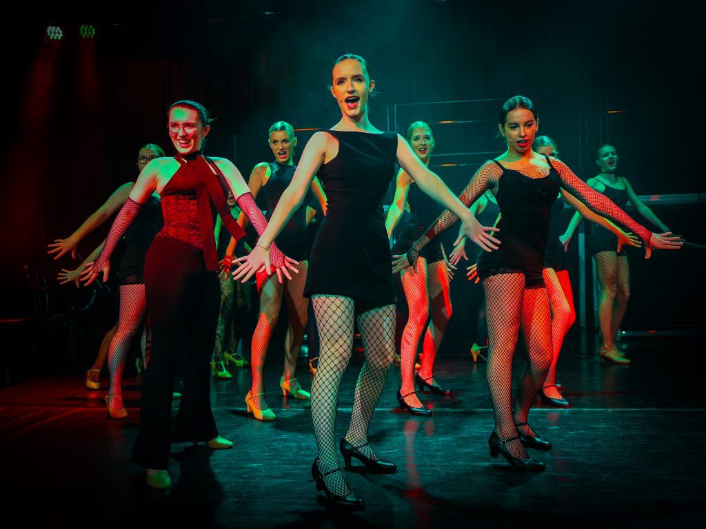 Dancers performing on stage with lights.