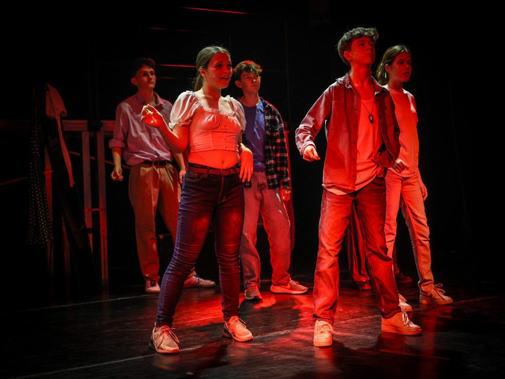 Group performing under dramatic lighting.