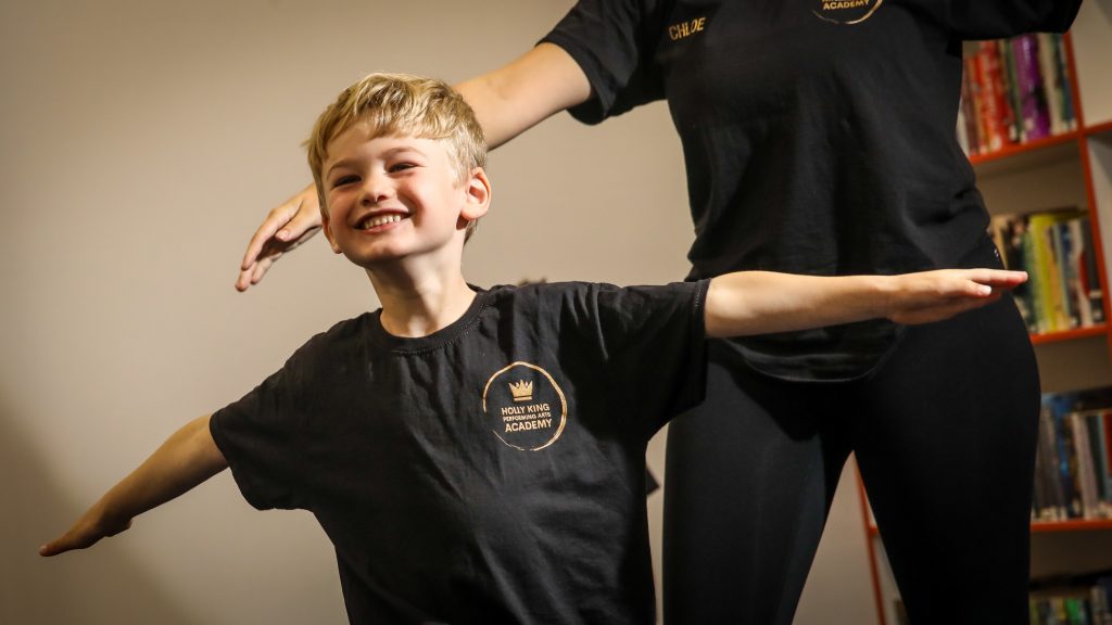 Little Performers.
Child practicing pose with instructor.