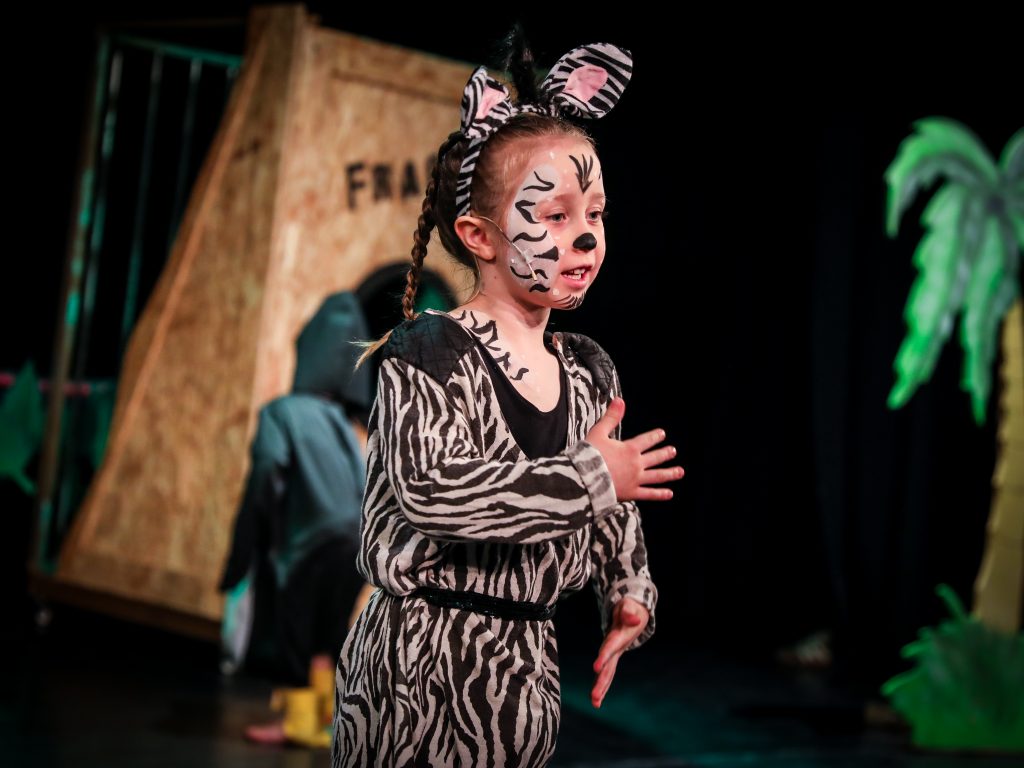 Child in zebra costume performing on stage