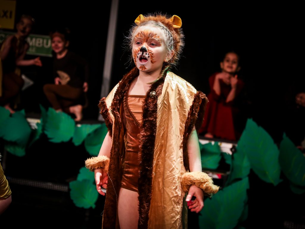 Child in lion costume performing