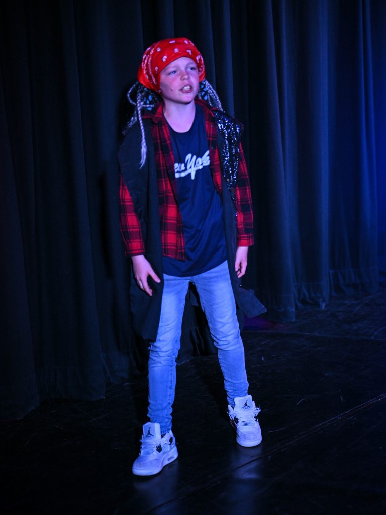 Child performing on stage, dressed creatively