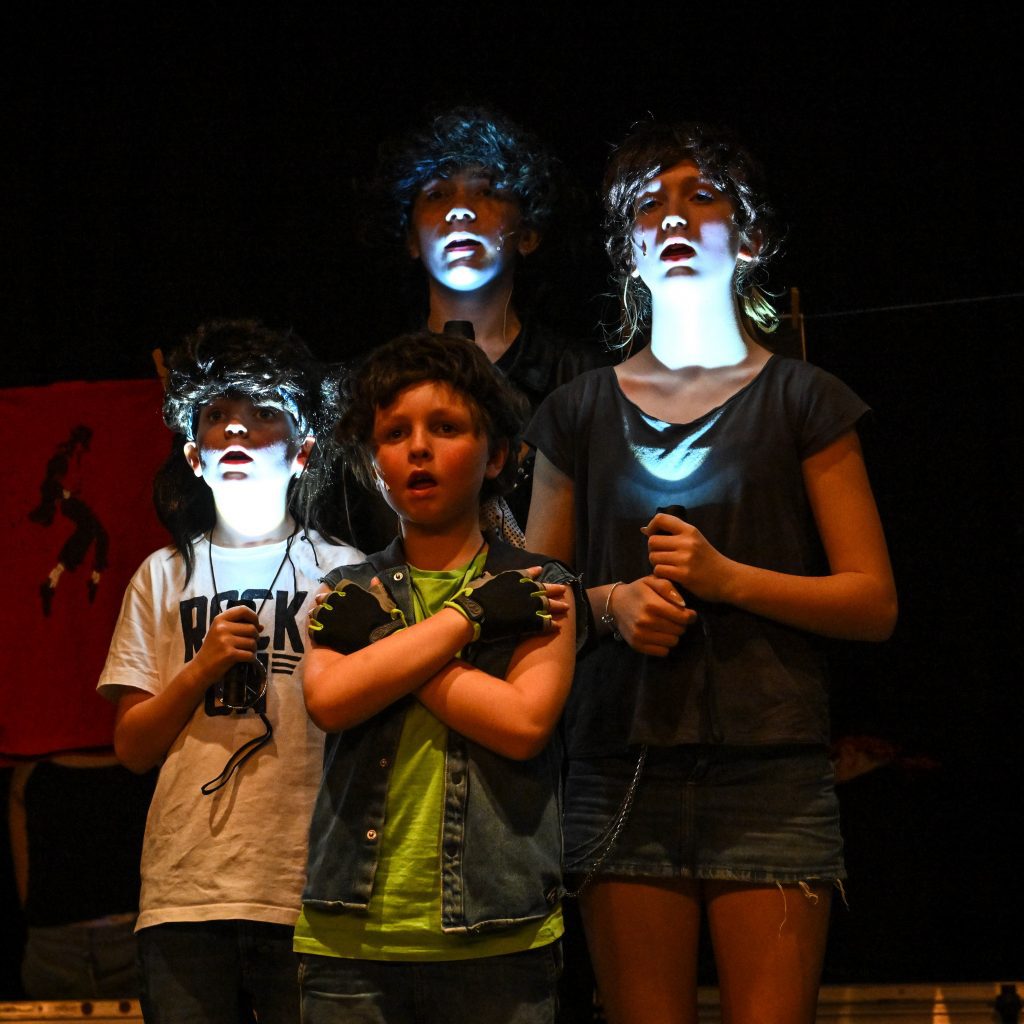 Children performing with dramatic lighting